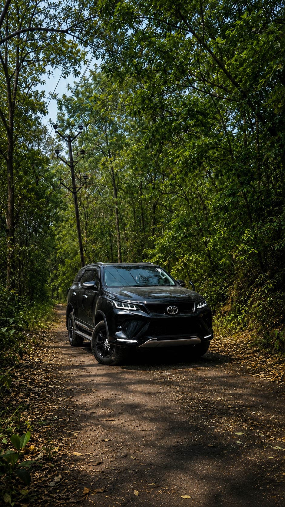 Black Toyota Fortuner on a forest road